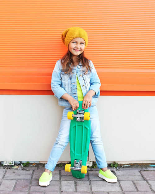 Girl-with-skateboard-on-orange-wall